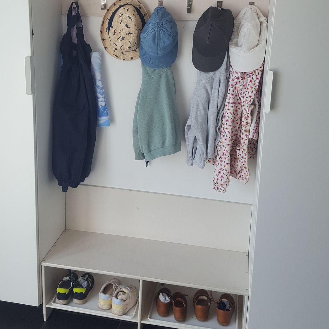 Foto der Garderobe mit Jacken, Mützen und Schuhen