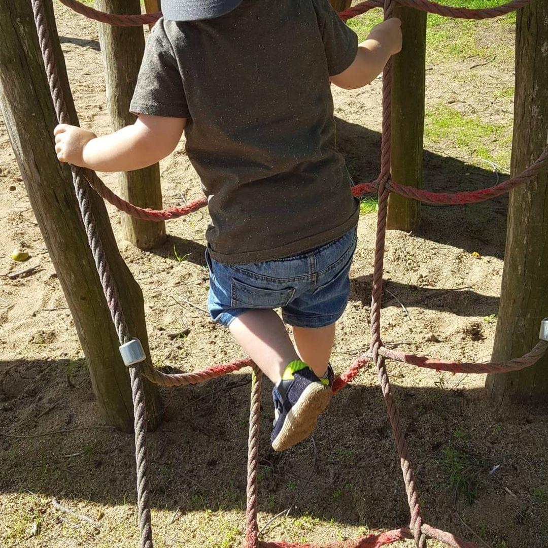 Foto eines Kindes, das ein Netz hochklettert