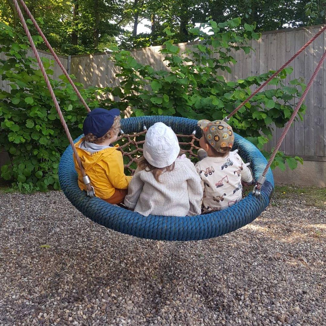 Foto von drei Kindern in einer Netzschaukel