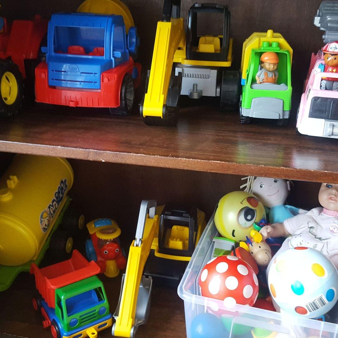 Foto eines offenen Spieleschranks u.a. mit Fahrzeugen, Kuscheltieren und Bällen